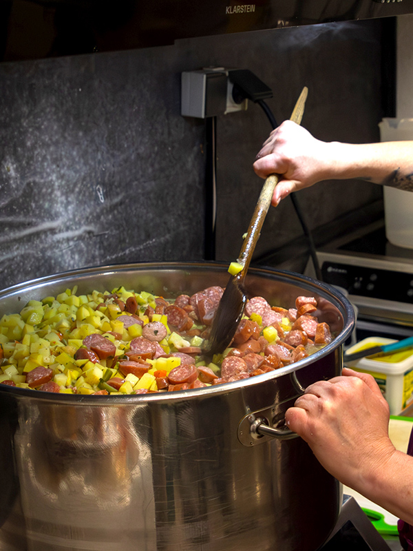 Ein Löffel rührt in einem Topf mit Suppe