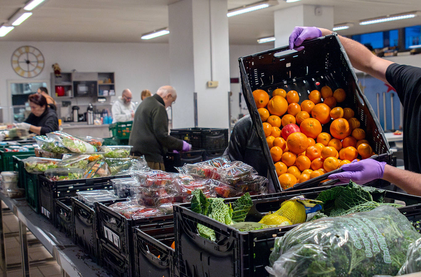 Lebensmittel in Kisten werden auf Tische platziert
